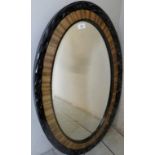 A c1900 carved ebonised and satin oval wall mirror,