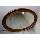 A 20th century gilt framed oval wall mirror with a bevelled mirror plate,