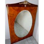 A 20th century large walnut framed wall mirror with an oval mirror plate and applied Ormolu mounts