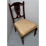 A 19th century carved low ladies nursing chair, upholstered in cream/gold material,