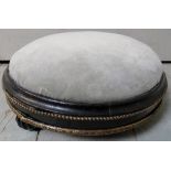 A small Victorian ebonised round foot stool with gold detailing,