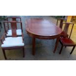 A 20th century Chinese hardwood dining table with two additional leaves and complete with eight