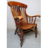 A large late 19th century/early 20th century Windsor fireside armchair with a carved back splat