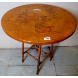 A 20th century round lamp table depicting Japanese figures and terminating on bamboo legs,