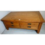 A 20th century golden oak coffee table with two deep double sided drawers and metal handles,