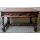 A Victorian carved oak writing table with two drawers over spiral twist upright supports and lower