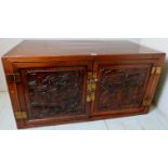 A 20th century Chinese hardwood cupboard with 2 detailed carved doors with brass lock,