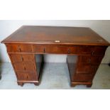 A 20th century pedestal desk with a brown leather top over 9 drawers with drop handles and