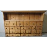 A fine Victorian pine wall mounted spice cabinet with a single shelf over 27 drawers,