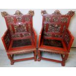 A superb pair of late 19th century Chinese red lacquered throne chairs with carved panels depicting