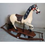 A 20th century painted wooden child's rocking horse on a platform base, in good condition,