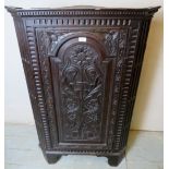 A Victorian carved oak corner cupboard with a carved panelled door over bracket feet,