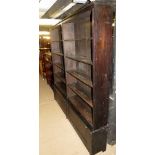 A large antique double open bookcase on base, with two fall front cupboards,