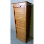 An early 20th century oak tambour filing cabinet in good order and bearing brass preservation