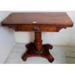A Regency rosewood turnover card table with a burgundy baize over a gun barrel column and platform