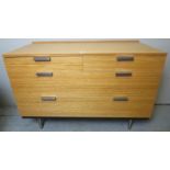 A mid to late 20th century pale chest of 2 short over 2 long drawers and terminating on chrome legs,