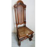 A Georgian Revival high back carved hall chair with a cane back and seat pad, slightly a/f,