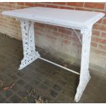 A Victorian white painted cast iron garden table, with a painted wooden top,