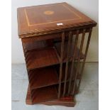 A 20th century mahogany inlaid revolving bookcase with a lift-up top revealing a hidden compartment,