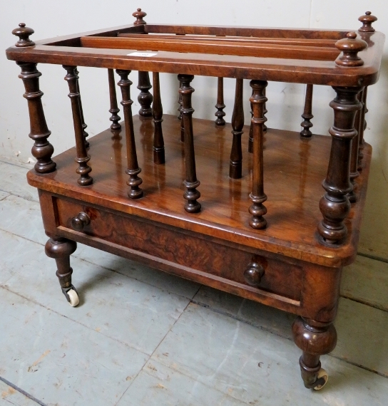 A pretty walnut Canterbury with turned upright spindles and magazine compartment over a single