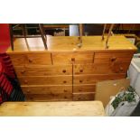 A LARGE MODERN PINE MULTI DRAWER CHEST WITH TURNED WOOD KNOB HANDLES SUPPORTED ON A PLAIN PLINTH