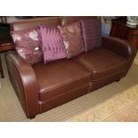 A MODERNIST CHOCOLATE BROWN, PROBABLY LEATHER UPHOLSTERED, TWO PERSON SETTEE with four contrasting