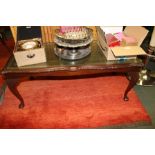 A REPRODUCTION MAHOGANY RECTANGULAR COFFEE TABLE with tooled leather inset top beneath glass