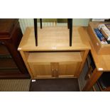 A MODERN OAK FINISHED SIDE CABINET with rectangular top over storage recess having two plain