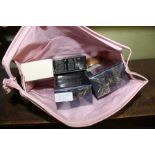 A LADY'S VANITY BAG containing a selection of unused perfumes, various