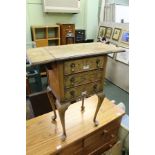 A REPRODUCTION WALNUT COLOURED TWIN FLAP TOPPED BEDSIDE UNIT WITH THREE FULL WIDTH DRAWERS SUPPORTED