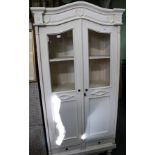 AN OFF WHITE PAINTED SHABBY CHIC ARCH TOPPED CUPBOARD UNIT having fancy decorative crest rail over