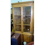 A MID 20TH CENTURY OAK FINISHED CORNER UNIT, with two plain glazed cupboard doors revealing