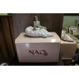 A LARGE NAO SPANISH PORCELAIN FEMALE FIGURINE SEATED UPON THE GROUND, sold with original box