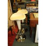 A PAIR OF RETRO DESIGN GAS LIFT BAR STOOLS each having buttermilk coloured seat, on a chromed base