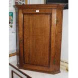 A 19TH CENTURY OAK FINISHED HANGING CORNER CUPBOARD with single mahogany crossbanded panel door,