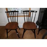 FOUR BELIEVED ERCOL STICK BACK SOLID SEATED DINING CHAIRS, finished in gloss black with natural