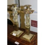 A PAIR OF AZTEC DESIGN CAST BRASS CANDLESTICKS