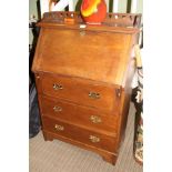 AN EARLY 20TH CENTURY OAK FINISHED BUREAU UNIT with fancy 3/4 upright with cut out heart design, the