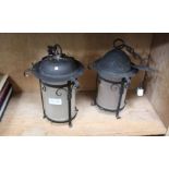 A PAIR OF BLACK METAL FRAMED FROSTED GLASS SHADED HANGING LANTERNS