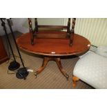 AN UNUSUAL MAHOGANY AND ROSEWOOD CROSS BANDED OVAL TOPPED COFFEE TABLE on single column and four