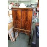 A REPRODUCTION MAHOGANY CASED DRINKS CABINET having blonde wood interior with mirrored back and