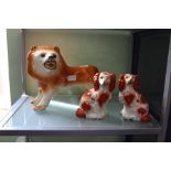 A STAFFORDSHIRE POTTERY LION together with a PAIR OF SMALL SIZED HEARTH SPANIELS