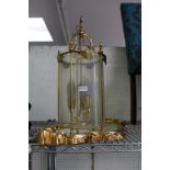 A GILDED WALL MIRROR TOGETHER WITH A BRASS AND GLASS THREE SCONCE HANGING LANTERN