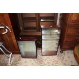TWO SLENDER WALL MOUNTABLE COLLECTOR'S CABINETS WITH MIRRORED BACK AND GLASS SHELVES