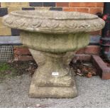 A WELL WEATHERED CAST CONCRETE PEDESTAL PLANTER