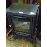 A SMALL BLACK FINISHED ELECTRIC ROOM HEATER IN THE FORM OF A SOLID FUEL BURNER