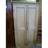 A PINE TWO DOOR SIDE CABINET WITH TRIPLE SHELVED INTERIOR