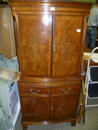 A REPRODUCTION BEVAN FUNNELL WALNUT COLOURED BOW FRONT CABINET, the upper section having two doors
