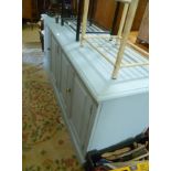 A BLUE PAINTED PROBABLE PINE DRESSER having plain flat top over four panelled doors, supported on