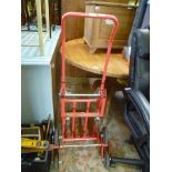 A RED FINISHED METAL SACK TRUCK WITH STAIR STEPPING ACTION